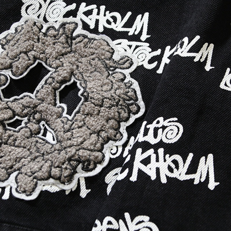 American-style baseball jacket Stu x Tears American High-Street Collaboration: Denim Jacket Featuring All-Over Barrage Text Print and Embroidered Cotton Boll Motifs.